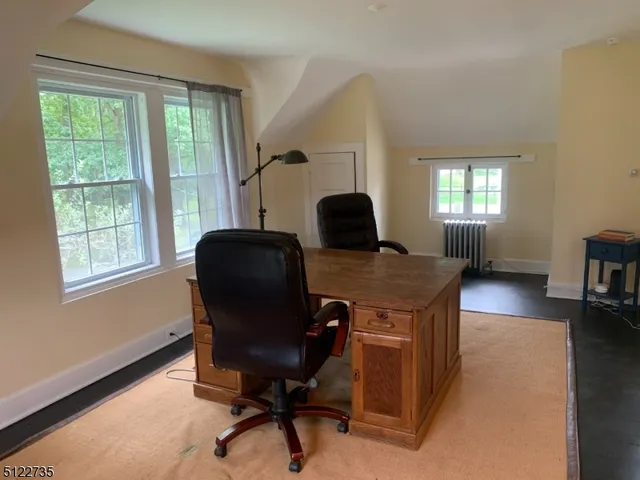 a view of a workspace with furniture and a window