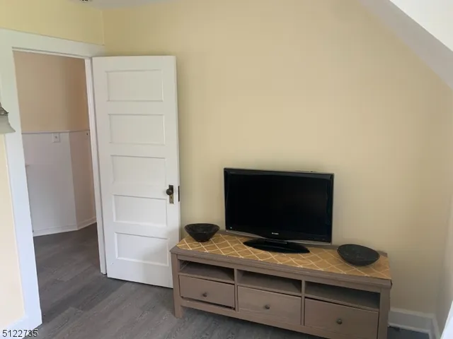 a living room with a flat screen tv and dresser