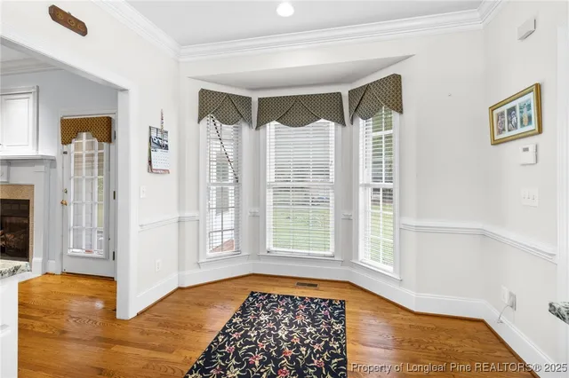a view of a bedroom with wooden floor and windows