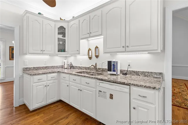 a kitchen with granite countertop white cabinets and sink