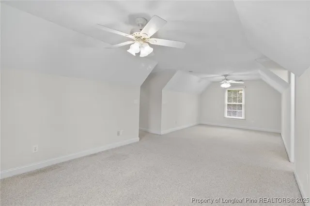 a view of a big room with chandelier fan and windows