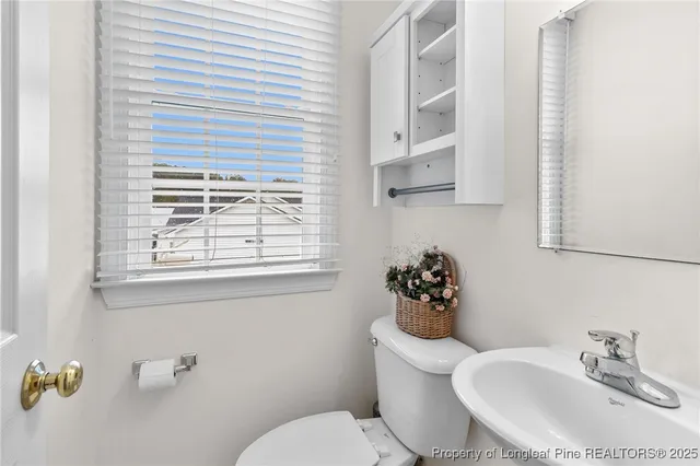 a bathroom with a sink mirror and toilet