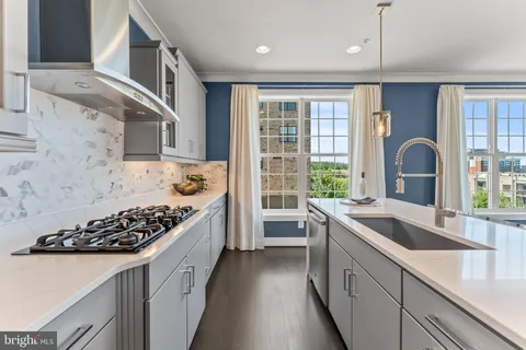 a kitchen with stainless steel appliances a sink stove and cabinets