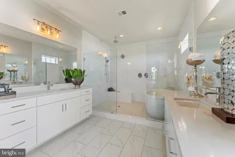 a large bathroom with a double vanity sink a large mirror and a shower