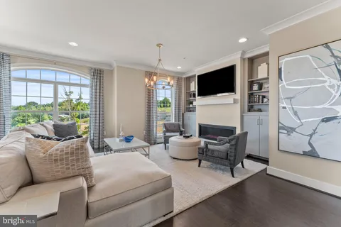 a living room with furniture a flat screen tv and a large window