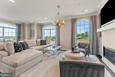 a living room with furniture a flat screen tv and a large window
