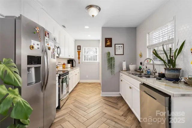 a kitchen with stainless steel appliances kitchen island granite countertop a refrigerator and a sink