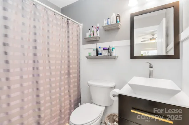 a bathroom with a toilet a sink and a mirror