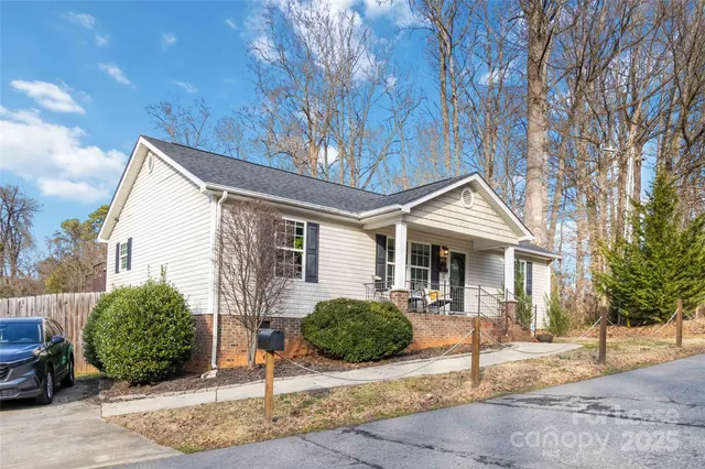 a view of a house with a yard and large tree