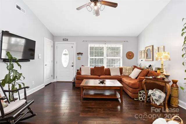 a living room with furniture flat screen tv and a large window