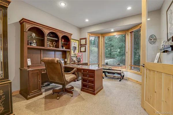 a view of a workspace with furniture and a window