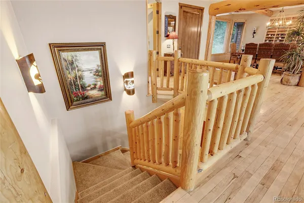 a view of staircase with lots of frames on wall and a wooden floor