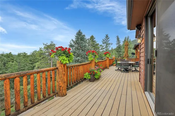 a balcony with wooden floor and potted plants