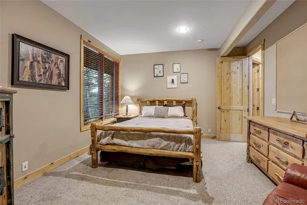 a spacious bedroom with a bed and wooden floor