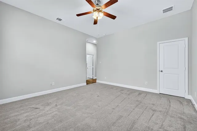 an empty room with closet and a chandelier fan