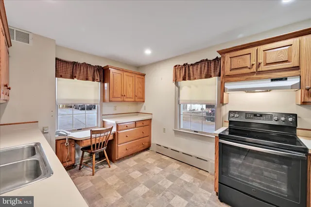 a kitchen with stainless steel appliances kitchen island granite countertop a stove a sink and a microwave