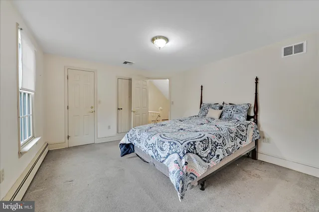 a spacious bedroom with a bed and a window