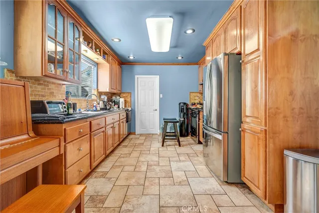 a kitchen with stainless steel appliances granite countertop a refrigerator and a sink