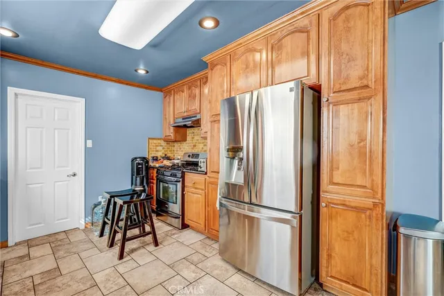 a kitchen with a refrigerator and more cabinets