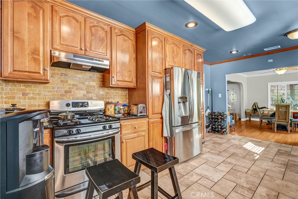 4816 Stratford Road Los Angeles, CA 90042 - Photo 18 of 20 a kitchen with stainless steel appliances granite countertop a stove refrigerator sink and cabinets