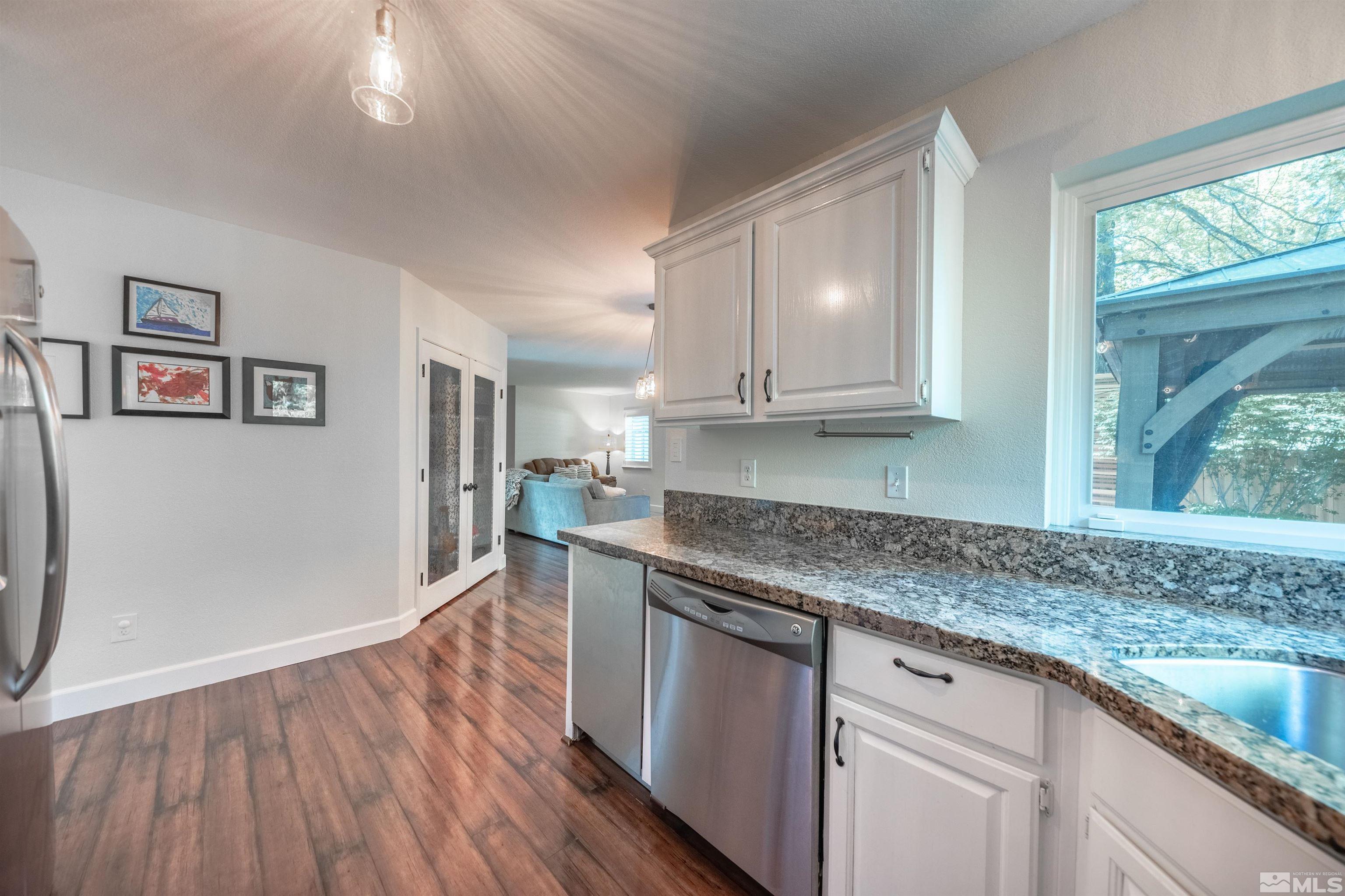 110 Riverhaven Place Reno, NV 89519 - Photo 13 of 40 a kitchen with granite countertop a sink cabinets and wooden floor