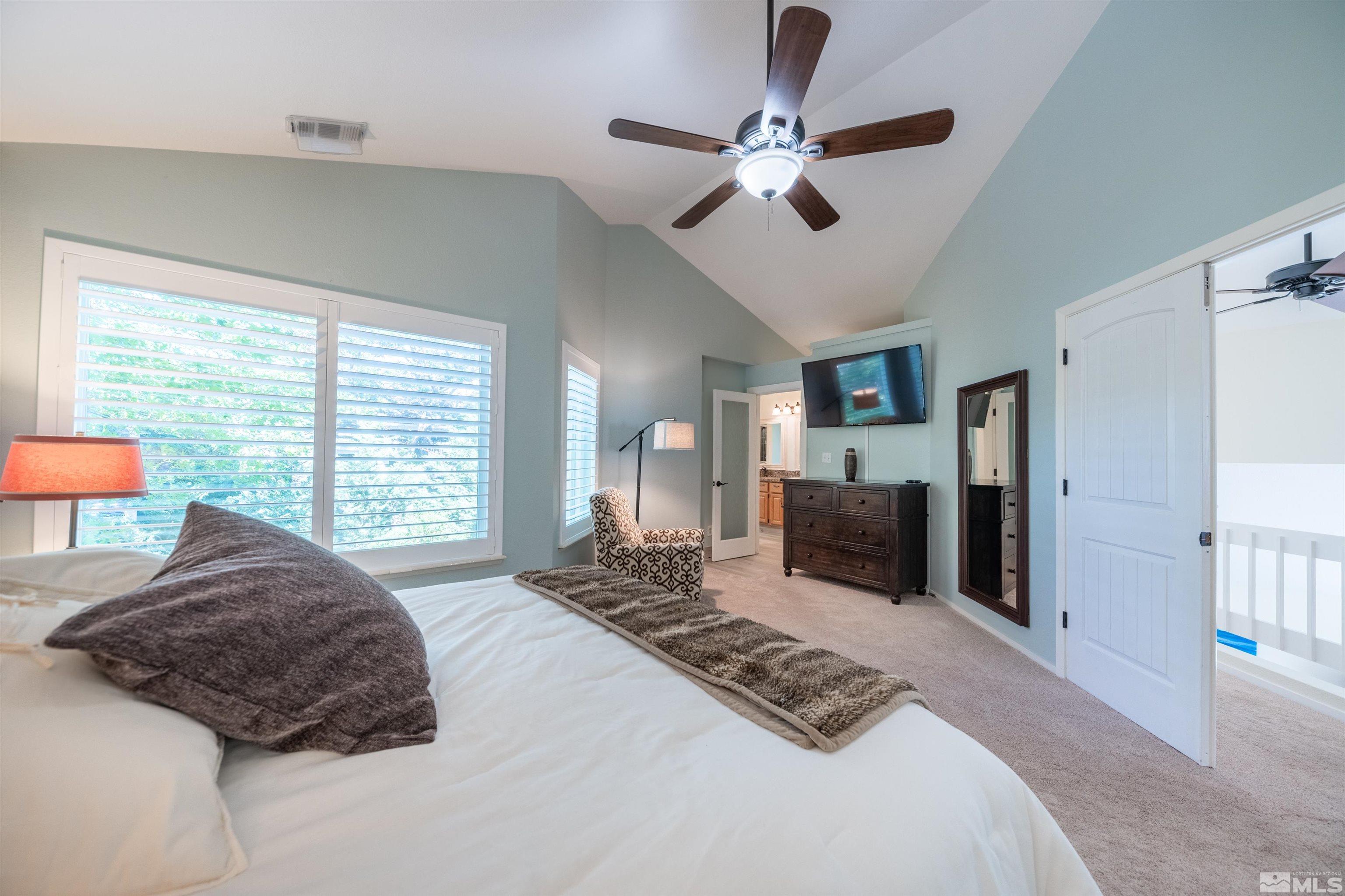 110 Riverhaven Place Reno, NV 89519 - Photo 23 of 40 a bedroom with a large bed and a chandelier