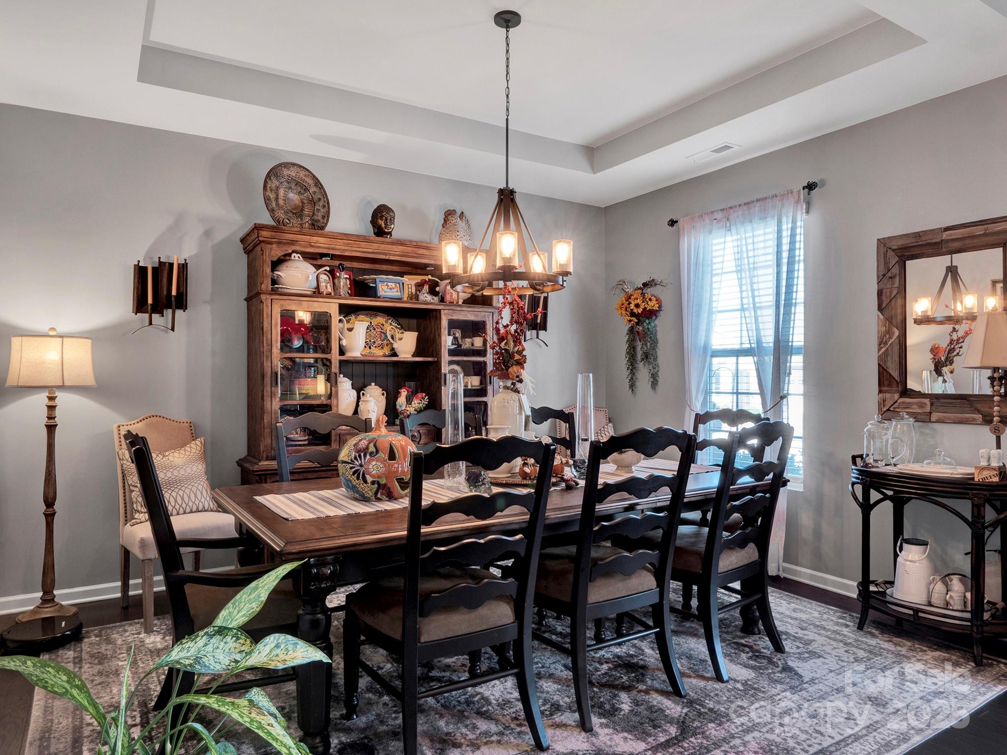 3129 Bridgewater Street, Unit 3E61 Lancaster, SC 29720 - Photo 5 of 48 a view of a dining room and livingroom with furniture wooden floor a rug a painting and a chandelier