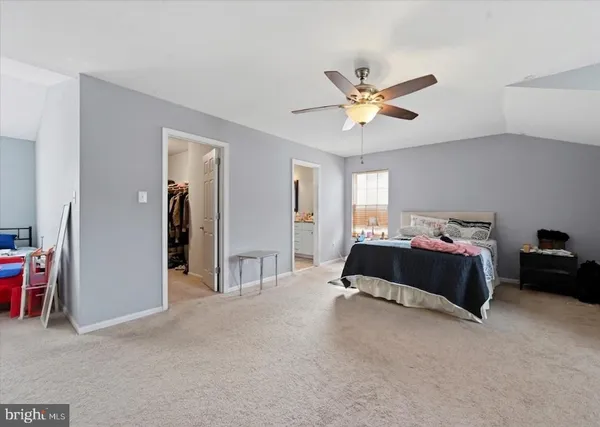 a spacious bedroom with a bed and a chandelier