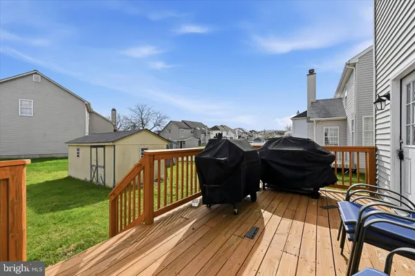 a view of a roof deck with table and chairs with wooden floor and fence