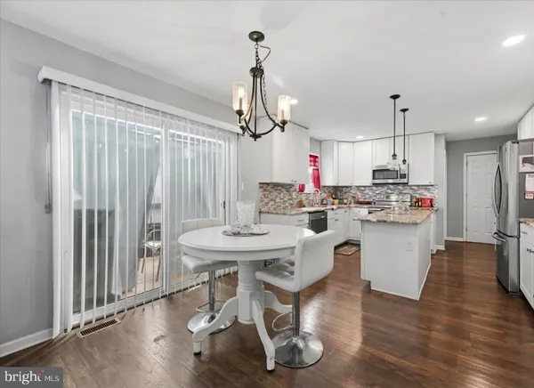 a kitchen with kitchen island stainless steel appliances a table and chairs