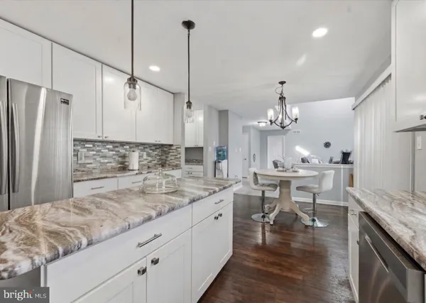 a large kitchen with kitchen island a sink stove a dining table and chairs
