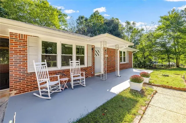 a bathroom with a granite countertop sink a mirror and shower