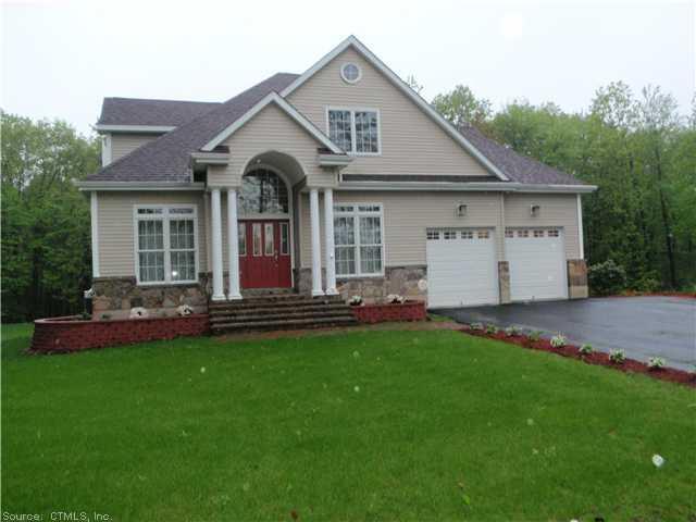 a front view of a house with a garden and yard