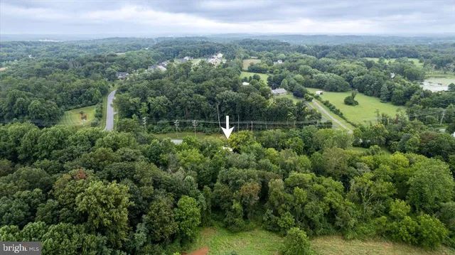 an aerial view of residential house with outdoor space and trees all around