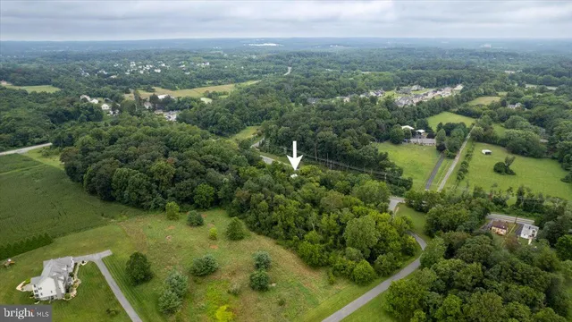 an aerial view of a residential houses with outdoor space and trees