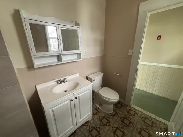 a bathroom with a sink toilet and window
