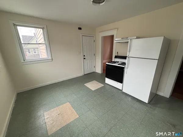 a kitchen with a refrigerator and a stove top oven