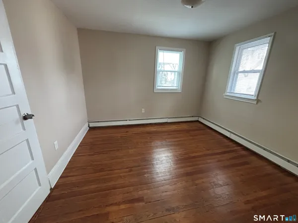 a view of a room with wooden floor and window