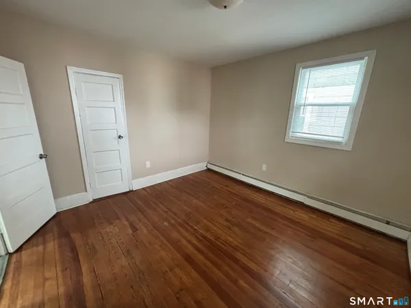 a view of a room with wooden floor and window