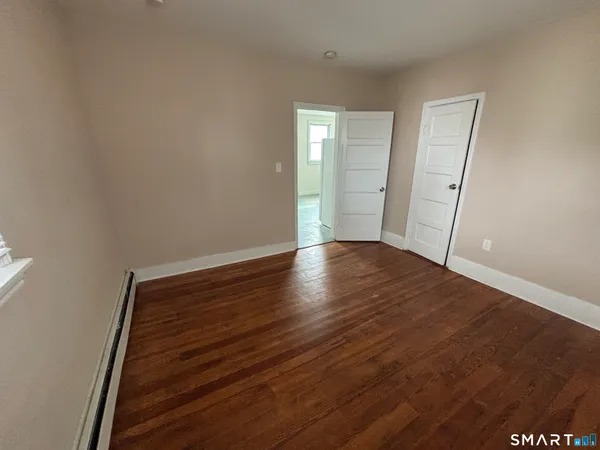 a view of an empty room with wooden floor
