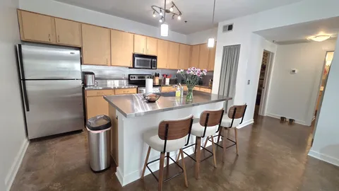 a kitchen with stainless steel appliances granite countertop a refrigerator a stove a sink dishwasher and a refrigerator with wooden floor