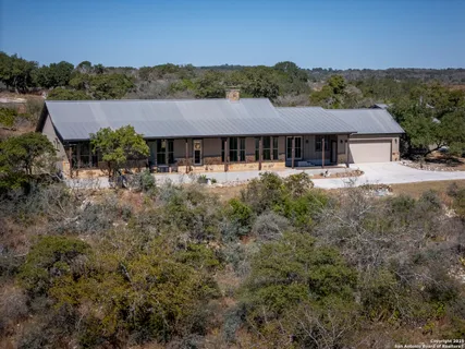 a view of a big house with a big yard and large tree