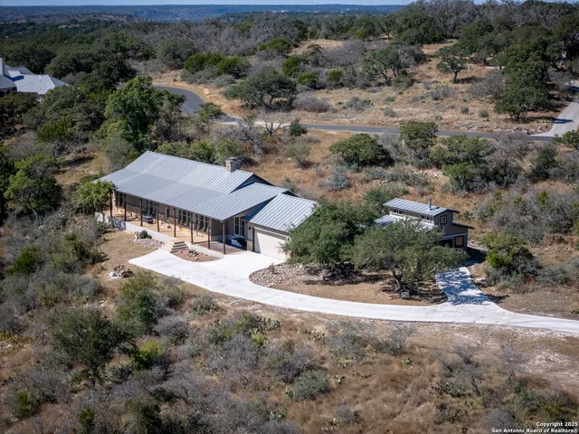 an aerial view of a house with a yard and lake view