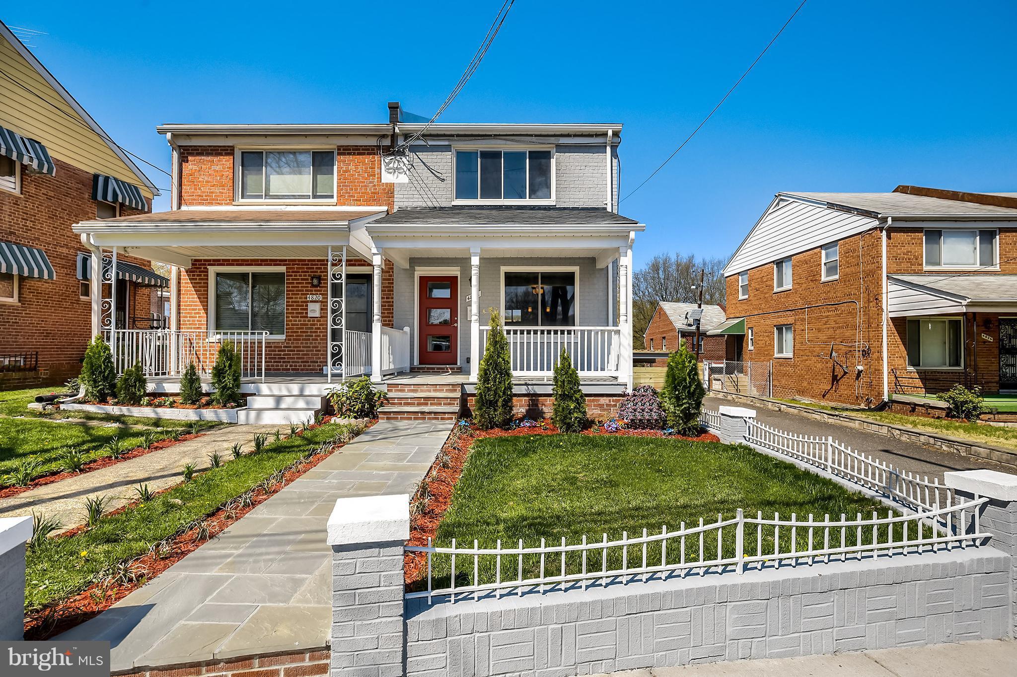 4822 Sargent Road Northeast Washington, DC 20017 - Photo 1 of 30 a view of a brick house with a yard plants and large tree