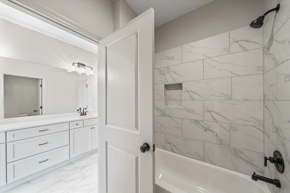 926 Aldwick Drive Collierville, TN 38017 - Photo 26 of 39 a bathroom with a granite countertop sink a mirror and a bathtub