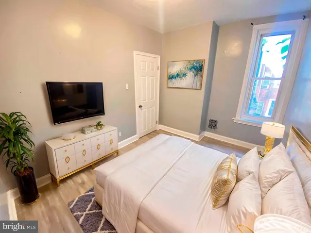 a bedroom with a flat screen tv and a bed