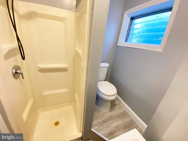 a white toilet sitting next to a shower