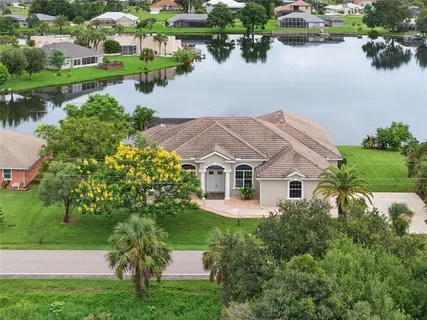 a front view of a house with a yard and lake view