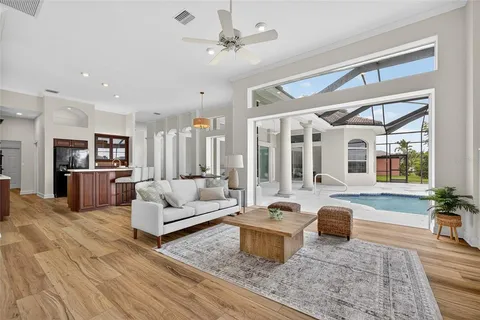 a living room with furniture kitchen view and a large window