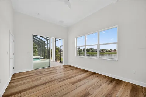 a view of an empty room with a window and wooden floor